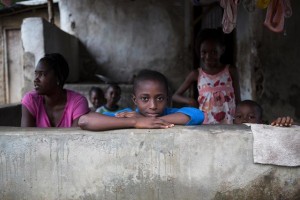 On 25 September, (centre) Ernest, 7, leans against a low wall in a village on the outskirts of the city of Kenema in Eastern Province. Several other children and a woman are around him. Many of the people in the village are affected by Ebola. Im bored because there is no more school, Ernest said. I really miss my English teacher, he was always making jokes. I hope this Ebola problem goes away soon so we can continue learning. Kenema District is under quarantine. In an attempt to curb spread of the disease, almost half of Sierra Leones 6.34 million population is now under quarantine. Primary and secondary schools remain closed across the country because of the Ebola crisis. On 1 October 2014, Sierra Leone is among countries in West Africa affected by the worst outeak of Ebola virus disease (EVD) in history. As of 16 September, UNICEF estimates that 8.5 million children and young people under the age of 20 live in areas affected by EVD in Guinea, Liberia and Sierra Leone, countries where disease transmission is widespread and intense. Of these, 2.5 million are under the age of 5. Preliminary UNICEF estimates (as of 30 September) also indicate that at least 3,700 children in the three countries have lost one or both parents to EVD since the start of the outeak. By 1 October, 4,080 cases and 2,071 deaths had been confirmed in Guinea, Liberia, and Sierra Leone. UNICEF remains at the forefront of efforts to respond to and help curtail the outeak, and is the lead agency for the United Nations on social mobilization in the Ebola response. In Sierra Leone  where 2,179 cases and 575 EVD deaths were confirmed by 1 October  UNICEF is supporting social mobilization efforts, including Ebola prevention messaging and outreach and the creation and distribution of awareness-raising materials. UNICEF assistance also includes psychosocial support for patients and their families, contact persons and community members affected by EVD; training for medical