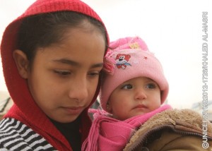 Both bundled in winter clothing, a girl holds an infant, in Zaatari, a camp for Syrian refugees on the outskirts of Mafraq, capital of the northern Mafraq Governorate. The camp is currently hosting 66,394 people. On 20 December 2012 in Jordan, worsening winter conditions continue to threaten Syrian refugee children and their families. To date, 106,724 refugees from Syrias still escalating war have registered in Jordan with the United Nations High Commission for Refugees; an additional 41,868 are awaiting registration. Syrians have also fled to neighbouring Iraq, Lebanon and Turkey, and as far away as Egypt, inging the total number of registered refugees to 450,191. Inside Syria, some 2.5 million people have been affected by the conflict, of which 1.1 million are children. In Jordan, where the number of refugees continues to increase, UNICEF and partners are supporting the ongoing provision of winter supplies. In the Zaatari camp as well as in the King Abdullah Park and Cyber City transit sites for refugees, some 3,000 winter clothing kits for infants under age 1 are being distributed. Over 3,100 additional kits are also being procured for new arrivals during the winter. Additional support includes the ongoing installation of gas boilers to provide hot water in Zaataris 90 existing water, sanitation and hygiene units and the construction of 192 fully winterized units in new areas of the camp. UNICEF also supports initiatives in health, nutrition, water, sanitation and hygiene, education and child protection, including the provision of child-friendly spaces and psychosocial assistance for children traumatized by their experiences in relation to the conflict. Working with diverse governments, other United Nations organizations and local and international NGOs, UNICEF continues to respond to the needs of affected children in all host countries and inside Syria. To continue these responses over the first six months of 2013, UNICEF requires US$180 million.