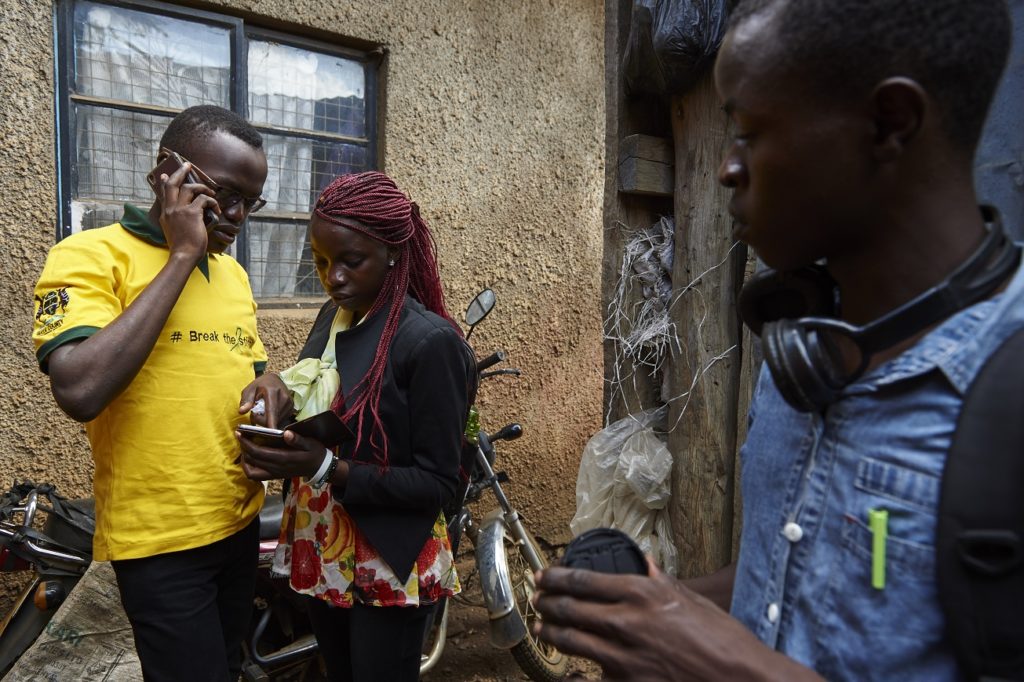 Standing in open, Collins Odour (left), Laura Adema (middle) and Dawwing Ouma (right), all of them Sauti Skika peers and advocates, communicate with their friends on phone in Nyalenda neighbourhood in the city of Kisumu. Kenya. Sauti Skika is an initiative for and by young people living with HIV, with a goal to ensure the voices of young people and adolescents living with HIV is heard at all levels of HIV response. It aims to empower adolescents living with HIV (ALHIV) to increase participation in advocacy for improved access to HIV prevention and treatment interventions, as well as for access to sexual reproductive health options and improve their quality of life. Sauti Sauti Skika seeks to have a pool of skilled and confident ‘Sauti Skika’ champions’ as agents for change who can engage in media related advocacy. Note: When given choice, Dawwing Ouma (grey shirt), Collins Odour (yellow shirt) and Laura Adema (black jacket) from Sauti Skika insisted that they are do not want their identities to be hidden in any way as they are advocates for people living with HIV. In Kenya, over half (51%) of new HIV infections are among adolescents and young people aged 15 to 24, at an estimated 49 new HIV infections every day among 15-19 year olds. Sauti Skika is an initiative supported by UNICEF, for and by young people living with HIV, with a goal to ensure the voice of young people and adolescents living with HIV is heard at all levels of HIV response. It aims to empower adolescents living with HIV (ALHIV) to increase participation in advocacy for improved access to HIV prevention and treatment interventions, as well as for access to sexual reproductive health options and improve their quality of life.