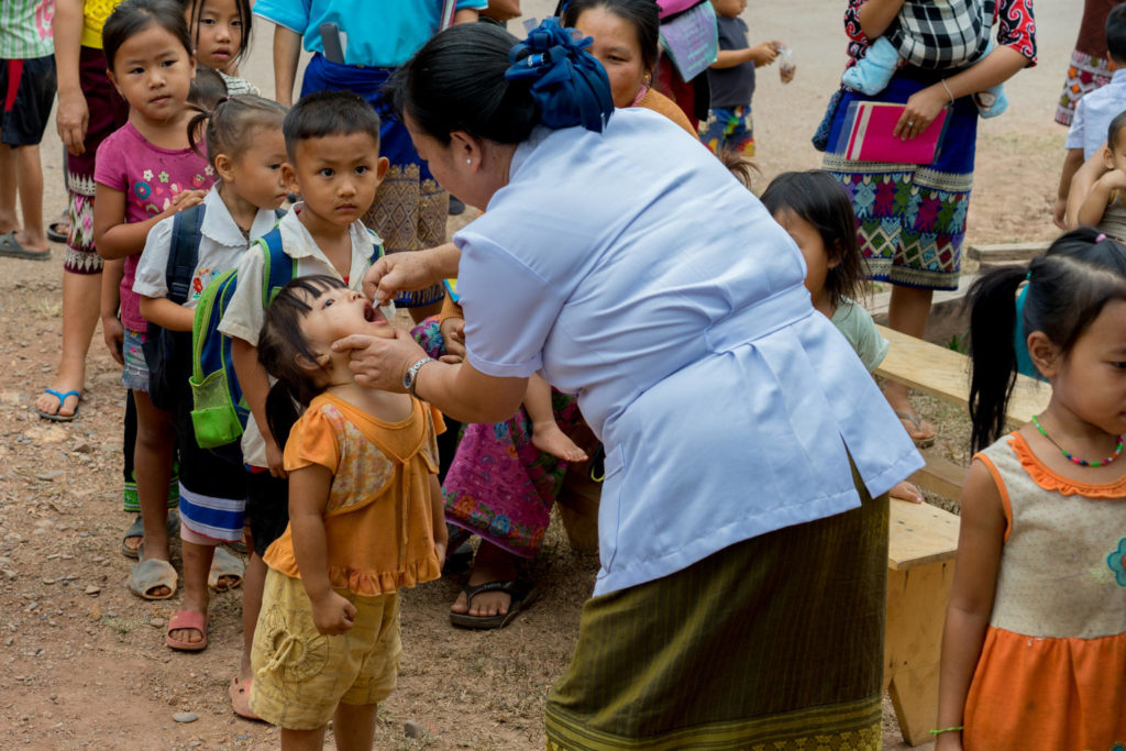 Daeng Xayaseng, Maternal and Child Health Manager, vaccinates children against polio in Nampoung village, Vientiane Province, Lao PDR. A 10-day polio vaccination campaign in 13 provinces in Lao PDR was undertaken in March 2018 to vaccinate about 460,000 at-risk children aged 0 months to 5 years of age. This is in response to a polio outeak in 2015 and 2016. More than 7,200 volunteers and 1,400 health workers ensured that all children within the 0 to 5 age group in the selected provinces and districts receive the two drops of oral polio vaccine. Children also received routine immunization vaccines. Throughout the campaign period, vaccines will be provided at health centres, as well as district and provincial hospitals, kindergartens, markets and bus stations. Furthermore, there will be outreach sessions, including house-to-house visits to identify and vaccinate children in high-risk areas, and special sessions in rice fields and other plantation areas. As of May 2017, Lao PDR is officially no longer infected with circulating-vaccine derived polio virus type 1 (cVPDV1). After the last outeak in 2015 and 2016, the country has now been without cases for over 24 months, with the last case reported in January 2016.