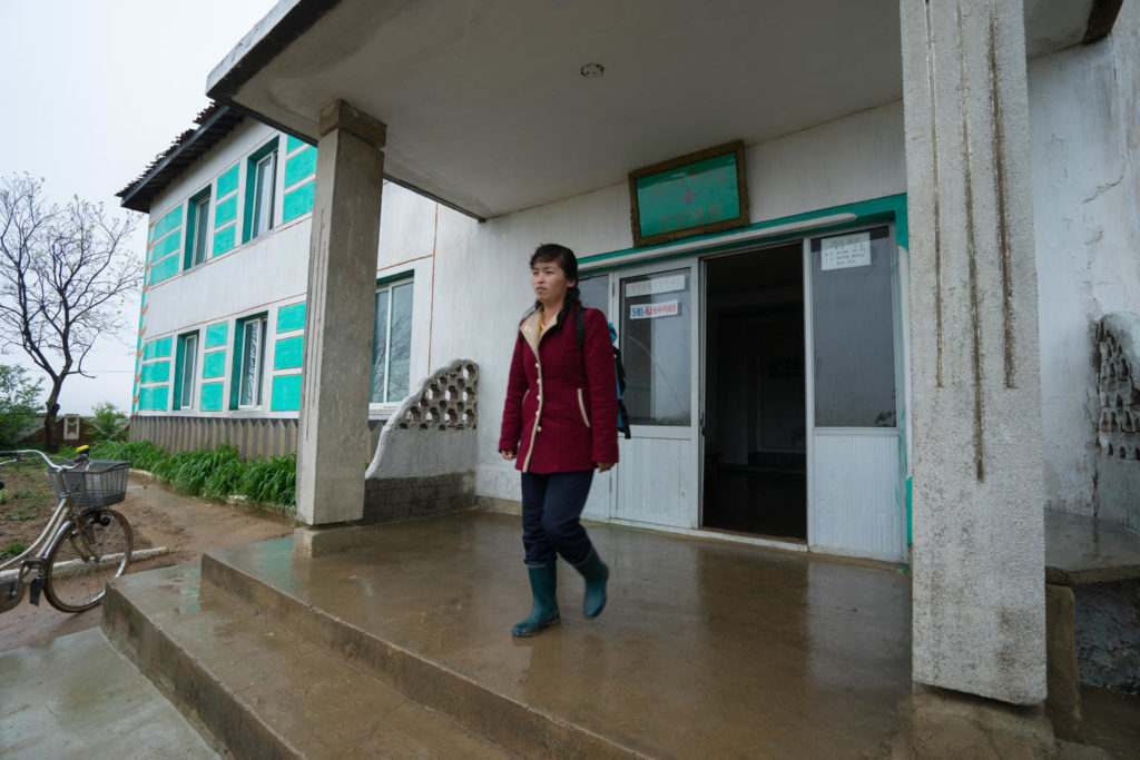 17 May 2018, Hwasan Ri, DPR Korea: For 9 years, Dr. Ri Chol Ok - pictured leaving her village clinic - has been trekking door to door to ing health care to the homes of families in a remote area of DPR Korea. “I cover 122 households, and in a single day I visit 20 to 30 families,” she explains. It’s not an easy job, she says, but thanks to a new bag provided by UNICEF, her work has become a little easier. “The bag is full of essential medical equipment and medicines which we commonly use, like antibiotics and oral rehydration salts (ORS),” says Dr Ri while checking the blue rucksack in preparation for her home visits today. “Before, we mostly used herbal medicines – it’s much better now.” In rural areas like this, children can be particularly vulnerable to diseases and illnesses. Rates of malnutrition and other related problems tend to be higher in rural areas and this year alone six children have been identified in this village. “It’s important to treat children with diarrhoea quickly and this bag allows us to deliver care to children fast,” she says before heading off to begin her shift for the day. “Today I’m first visiting two homes to check on children who had diarrhoea,” she says. “They’ve been treated and should be ok now, but I just want to check their status.” Dr. Ri leaves the clinic and quickly marches down a hill in her boots. It’s a relatively small village of less than 4000 people dispersed across the countryside. The first stop is to the home of 1-and-a-half-year-old Ri Song. “She had diarrhoea for two days and it didn’t stop,” explains her mother while Dr Ri checks the baby’s health. “We were given ORS and zinc tablets and after two days she’s better again.” Globally, diarrhoea is the second leading cause of death for children under five. Without the quick response and right medication provided by Dr Ri Chol Oh, children like young Ri Song would be a great risk. In addition to the bag